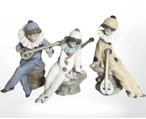 Three Nao figures of harlequin musicians.