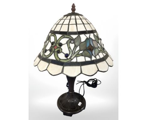 A patinated metal table lamp with tiffany style leaded glass shade, height 50 cm.