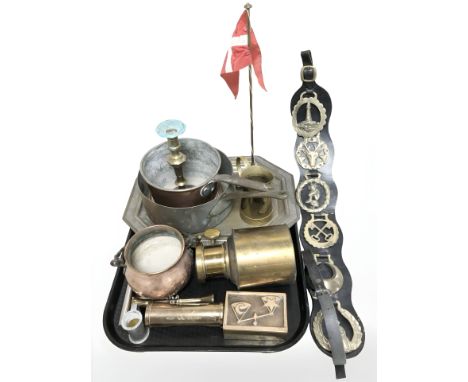 A group of brass and copper wares, desk flag pole, horse brasses on leather, swing handled couldron, corkscrew etc 