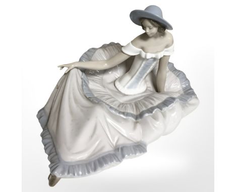 A Nao figure of a seated lady in flowing dress.