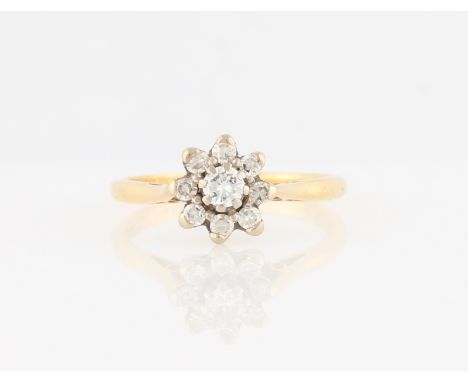 An 18ct yellow gold diamond flower design ring, set with a central round brilliant cut diamond surrounded by eight eight-cut 
