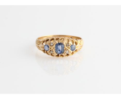 An 18ct yellow gold sapphire and diamond ring, set with three principal sapphires and four diamond accents, hallmarked Birmin