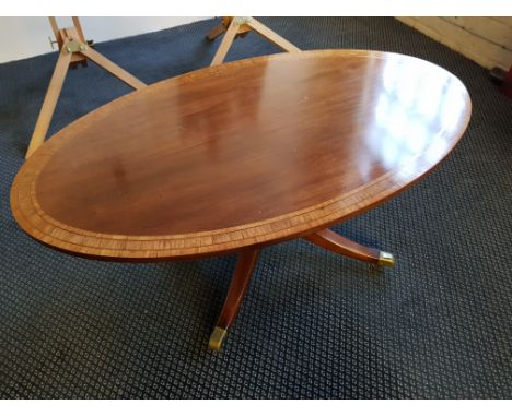 A reproduction oval mahogany coffee table on tripod base by Arthur Brett and small drop leg pedestal lamp table.