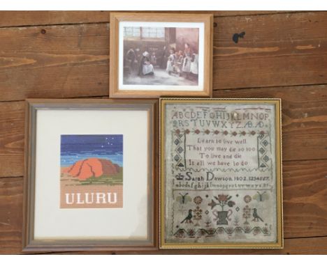 A framed Victorian sampler together with a framed, glazed Uluru textile and a small framed print of The Dole, St. Mary’s Chur