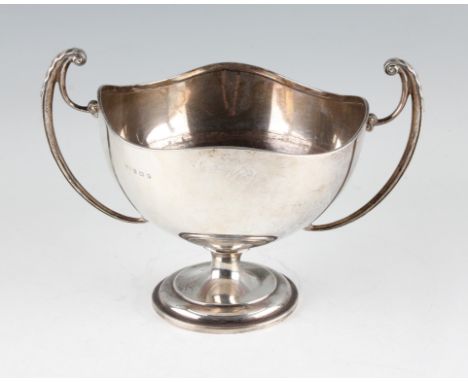 A silver twin handled trophy, with waved rim and scroll handles, raised on stepped circular foot, hallmarked Birmingham 1945,