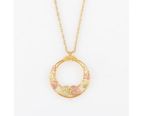 A 9ct two-tone gold pendant, of circular open metalwork design featuring leaves, hallmarked London import, date letter indist