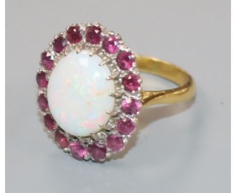 An 18ct gold, white opal and ruby set oval cluster dress ring, size L.