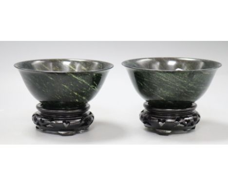 A pair of modern Chinese dark jade bowls with hardwood stands, boxed