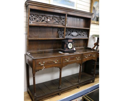 A George III oak dresser base, with associated two shelf rack, W.182cm H.192cm