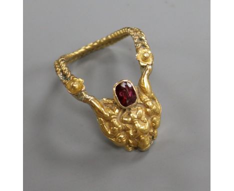 An Indian 22c and gem set 'deity' upfinger ring, size K.