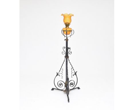A wrought iron and amber glass oil lamp standard, with amber shade and reservoir, the stand with tri-form scroll supports, 14