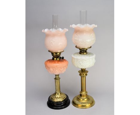An Edwardian brass and glass oil lamp, with moulded milk glass reservoir and shade above a plain candlestick stem and domed c