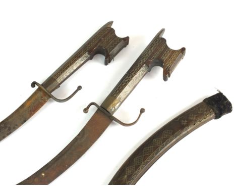 Two Moroccan or North-East African curved daggers (nimcha) late 19th/early 20th century with 35cm and 40cm long blades, the h