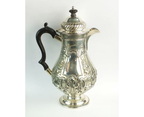 A late Victorian embossed silver hot water jug, Josiah Williams &amp; Co, London 1896, of baluster form with ebonised handle 