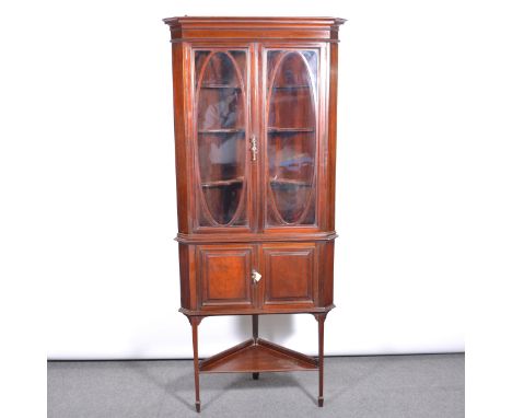 Late Victorian mahogany freestanding corner cabinet on stand, moulded cornice, glazed door, the base with a cupboard, square 