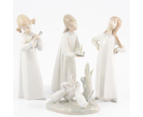 Three Lladro figurines of girls in nightgowns, each 20cm; and a Nao pottery group of geese by reeds, 13cm wide.