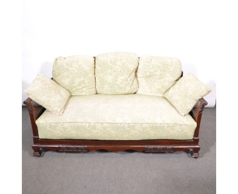 A walnut three-piece bergere suite, cane panel backs and arms, fixed upholstered seats with loose cushions, comprising a sofa