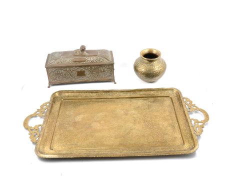 An Indian brass caddy, sarcophagus shape, the domed cover surmounted by a lion, the sides chased and embossed with Indian lan