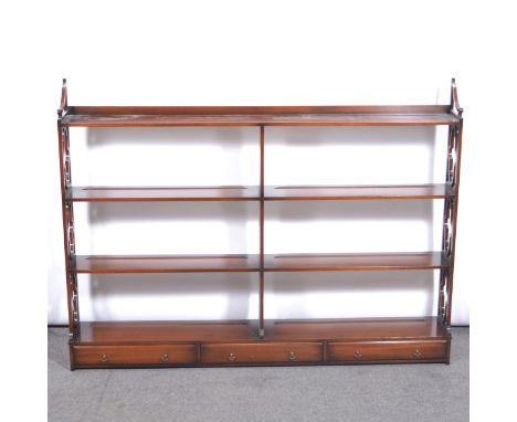 Reproduction mahogany wall shelf, three heights with quatrefoil fret ends, three drawers, width 138cm, height 105cm.