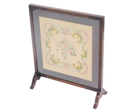 An early 20thC oak fire screen, with a floral woolwork tapestry, 66cm x 55cm. 