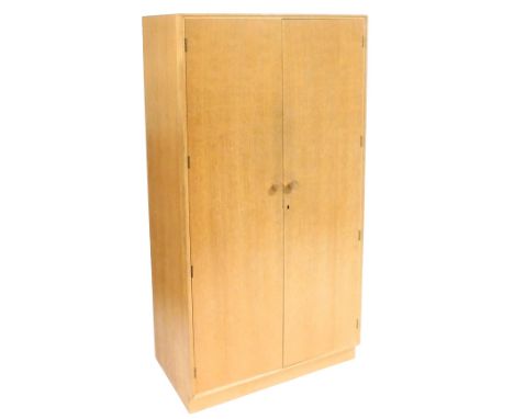 A Meredew light oak double wardrobe, the doors opening to reveal a shelf and hanging rail, raised on a plinth base, 176cm hig