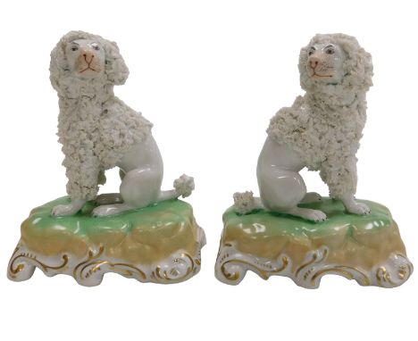 A pair of Dresden porcelain figures of Poodles, modelled seated on a rococo scroll cushion base, printed marks, 12.5cm high. 