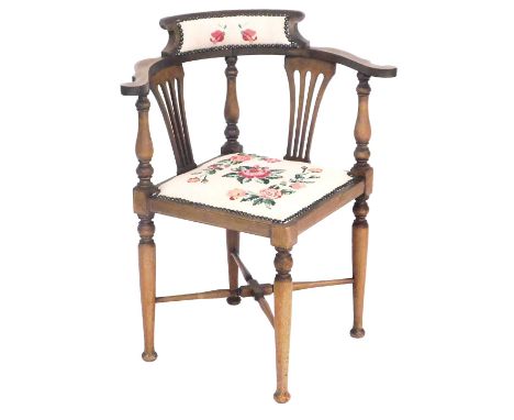 A Victorian mahogany and inlaid corner chair, with a rose decorated tapestry seat and back, raised on turned legs, united by 