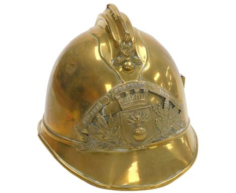 A French brass fire helmet, bearing a coat of arms beneath the banner "Sapeurs, Pompiers de Gilocourt"