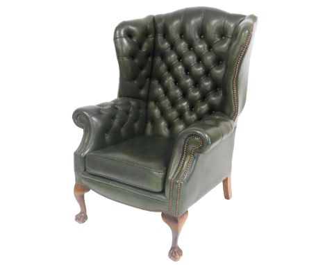 A green leather wing back armchair, with button back and arms, loose cushion seat, raised on cabriole legs, and claw feet, 80