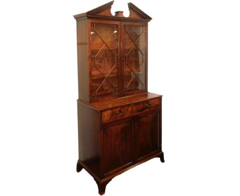 A George III mahogany secretaire bookcase, the broken arch pediment with dentil molding, with a pair of astragal glazed doors