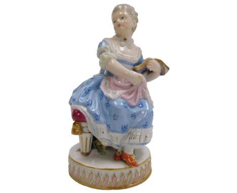 A late 19thC Meissen porcelain figure of a lady, seated on a stool, with a book in her left hand, raised on a circular base, 