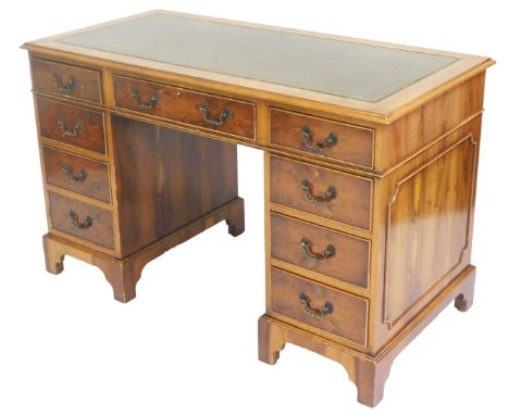 A yew wood twin pedestal desk, with a gilt tooled green leather top, above a central frieze drawer, flanked by eight further 