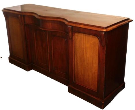 A Victorian mahogany serpentine topped sideboard, with a central cushion drawer over a pair of panelled doors, flanked by two