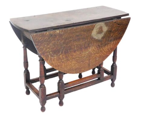 A Georgian oak gate leg dining table, raised on turned supports, united by a box stretcher, 71cm x 98cm x 40cm x 119cm extend