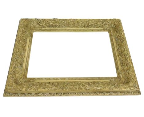 A simulated light wood plaster wall mirror, of rectangular form, with floral and foliate carving, and a bevelled mirror plate
