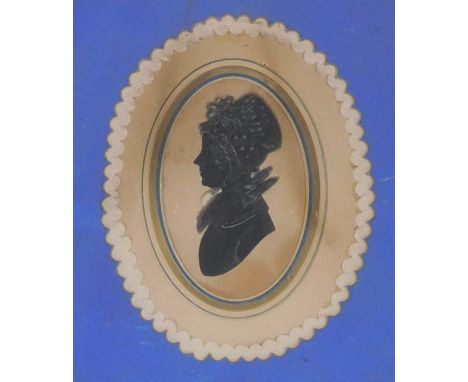 An early 19thC silhouette portrait of a lady, with a lace collar and mob cap, framed, 17cm x 14.5cm.