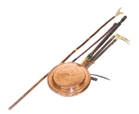 A Victorian copper bed pan, with a turned wooden handle, three riding crops, and a walking stick with a horn handle. (5)