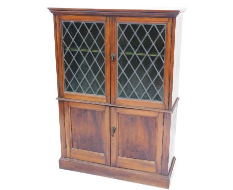 A Victorian mahogany cupboard bookcase, the outswept pediment over a pair of lead glazed doors, enclosing a single shelf, abo