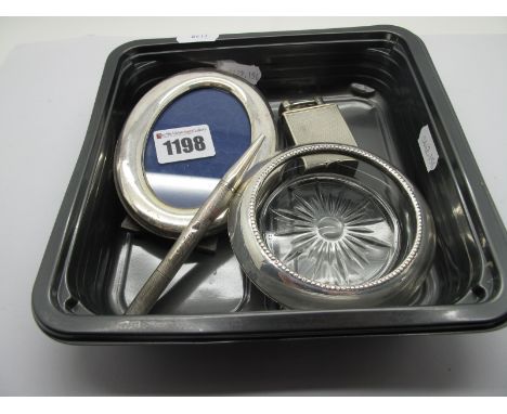 A Modern Oval Photograph Frame, (indistinctly stamped); a glass coaster, the mount stamped "Sterling"; a hallmarked silver en