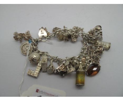 A Curb Link Charm Bracelet, to heart shape padlock clasp, suspending numerous novelty charm pendants, including long eared ra