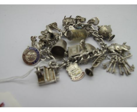 A Charm Bracelet, suspending assorted charm pendants, including pig, trumpet, pail, piano, gypsy caravan, teapot, bunch of ke