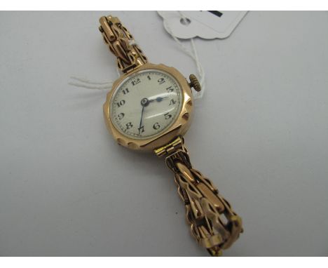 A 9ct Gold Cased Ladies Wristwatch, the unsigned white dial with Arabic numerals, in textured circular case to expanding pane