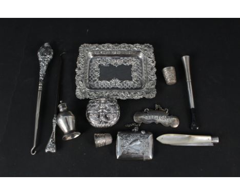 An embossed silver trinket dish, silver and white metal vesta cases, silver thimbles, white metal 'sherry' label, silver blad