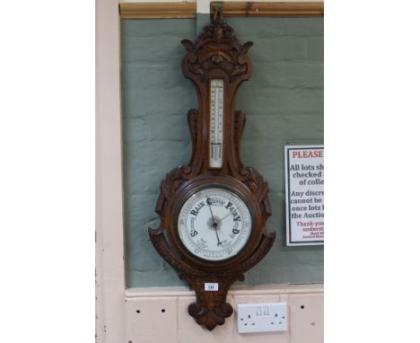 A carved oak aneroid barometer