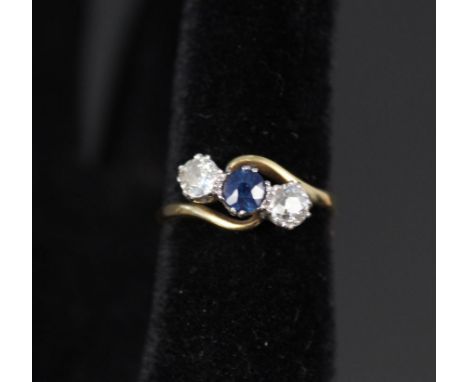 An 18ct platinum set sapphire and diamond three stone ring, size O