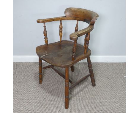 An early 20th century ash and elms smokers bow Armchair, raised on turned supports, note, split to seat which has been repair