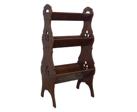 An Arts and Crafts three tiered Book Trough / Magazine Rack, with pierced carrying handles and decorations, with graduating s