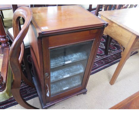 A 19th century mahogany music cabinet, glass panel to door with fitted shelves to interior raised on small bracket feet