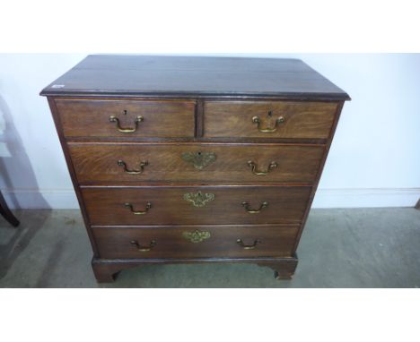 A 19th century oak chest of two short over three long graduated drawers raised on bracket supports, brass handles and escutch