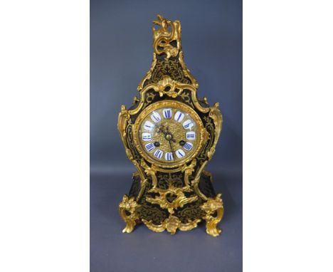 A French Boulle brass inlaid mantel clock with ormolu mounts with an 8cm diameter and gilt dial, striking on a bell with pend